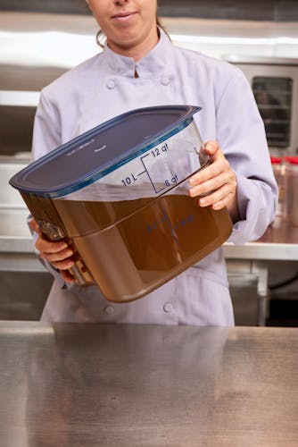Chef holding 12 QT FreshPro CamSquares with Easy Seal Cover